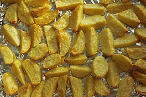 Baked potato wedges on foil. Top view.