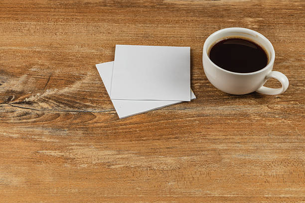 istock Warm cup of coffee beside blank notes on a wooden table 2242074568