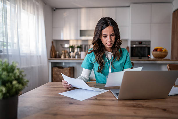 istock Nurse in scrubs working remotely from home kitchen 2242076487