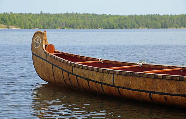 An Asian senior man covers his boat at a dock after a day of boating. Bamfield, Vancouver Island, British Columbia, Canada.