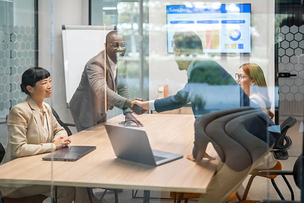 istock Business people shaking hands after successful meeting in modern office 2242089440