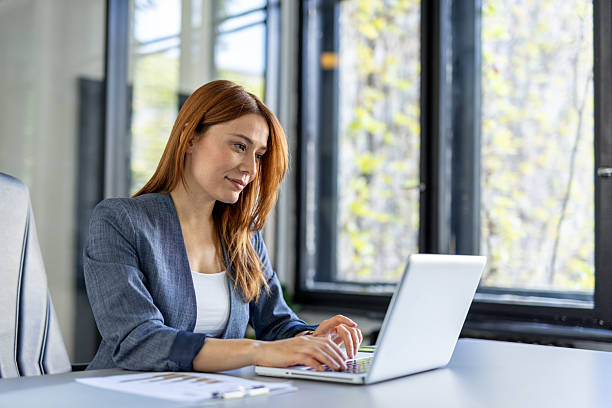 istock Professional Woman Working on Laptop in Bright Office Space 2242090343