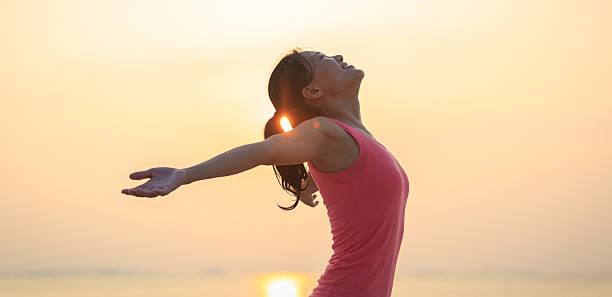 istock Woman open arms under the sunrise at seaside 2242090352