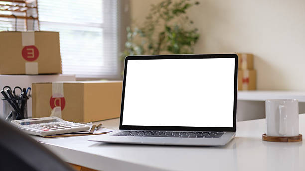 istock Laptop with blank screen and packaging boxes, for small business or e-commerce concept. 2242091639