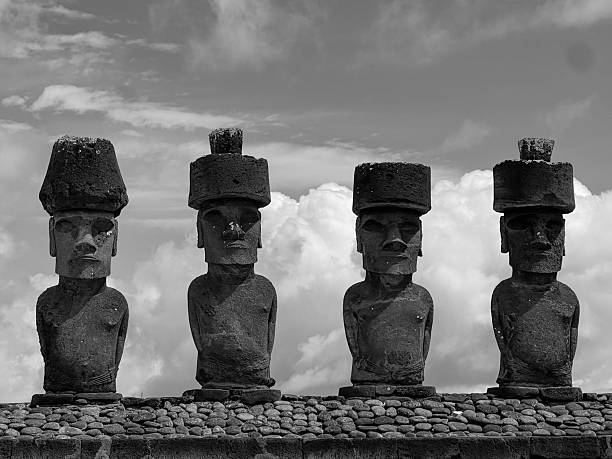 A striking black and white image of the iconic moai statues at Anakena Beach on Easter Island (Rapa Nui), Chile. These monolithic stone figures, carved centuries ago by the Rapa Nui people, stand majestically against a dramatic sky. The minimalism of the black and white tones emphasizes the texture, power, and mystery of these UNESCO World Heritage cultural treasures. Perfect for editorial, travel, cultural heritage, and fine art use.