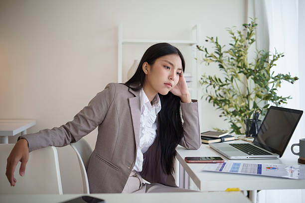 istock Businesswoman sitting at desk with a bored expression, feeling unmotivated at work. 2242092070