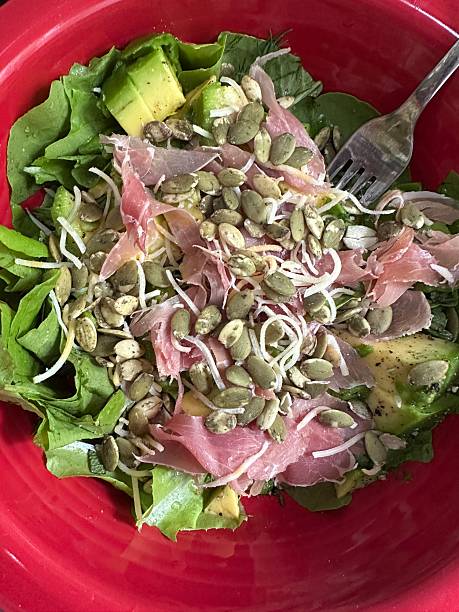 Fresh Green Salad of Hydroponically-Home-Grown Greens & Herbs in a Red Ceramic Bowl