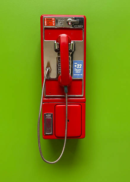 istock Shiny Red Vintage Pay Phone on Green Wall 2242095322