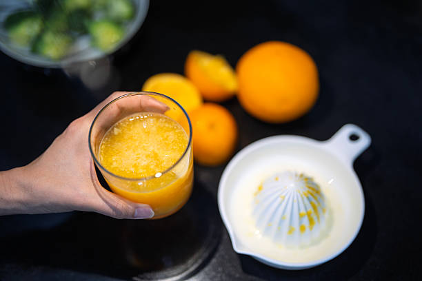 Freshly squeezed orange juice preparation in kitchen