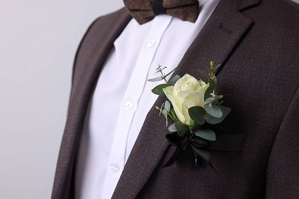 istock Handsome young groom with boutonniere on light grey background. Wedding accessory 2242095761