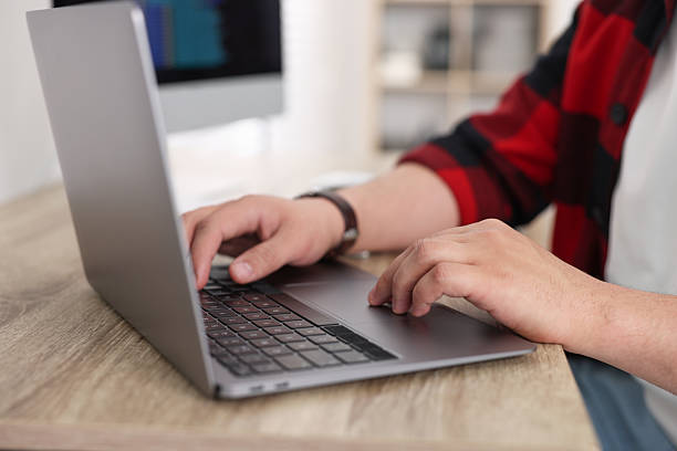 istock Programmer working with laptop at desk in office, closeup 2242095968