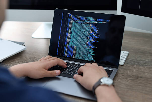 istock Programmer working with laptop at desk in office, closeup 2242095989
