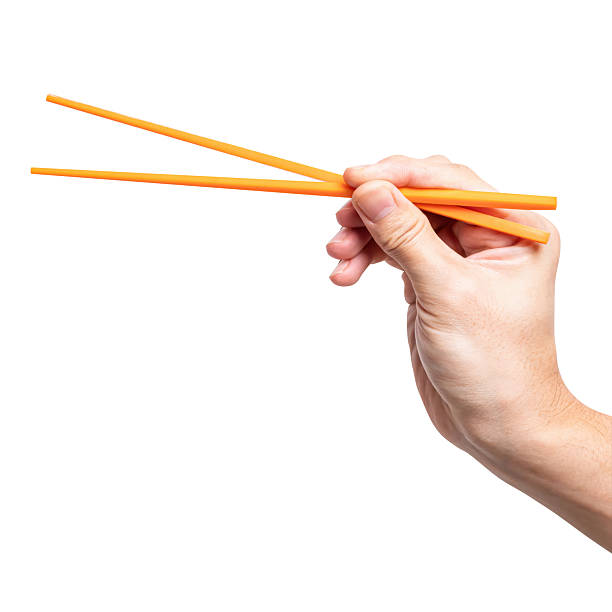 istock Male hand holding a orange plastic chopstick isolated on white background. 2242097176