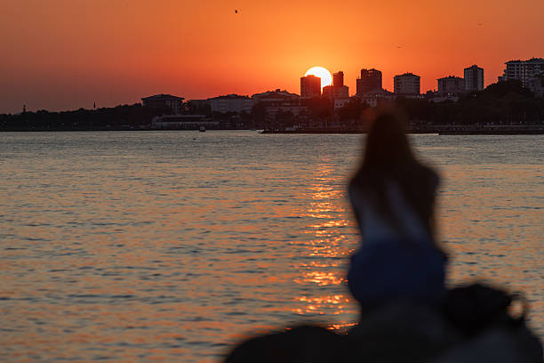 istock Young woman silhouette with sunset landscape. 2242099666