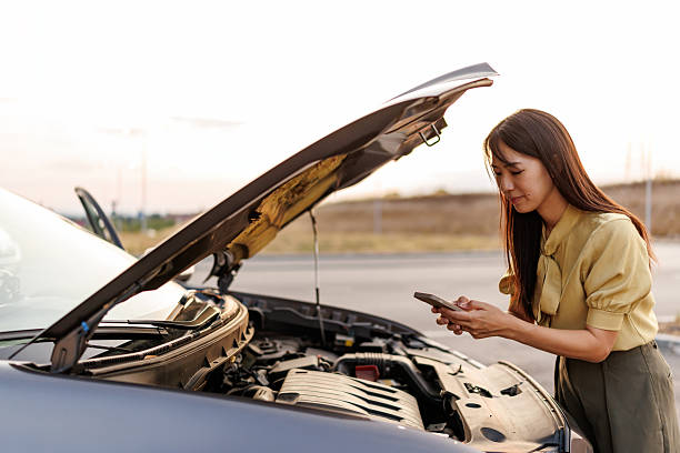 istock Frustrated Asian Woman Stranded Beside Her Broken Car, Calling for Roadside Assistance on Smartphone 2242102248