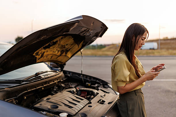 istock Stressed Asian woman using smart phone to call roadside assistance after car breakdown on quiet rural road 2242102384