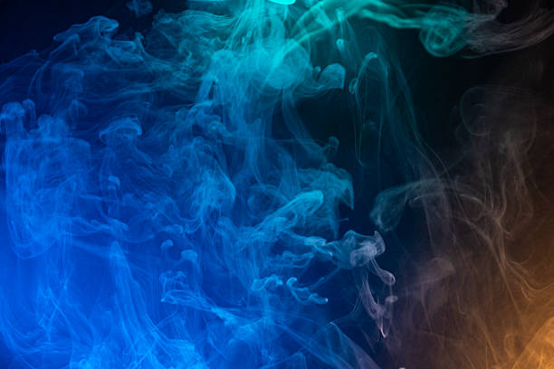 Illuminated multi color smoke on a dark background.