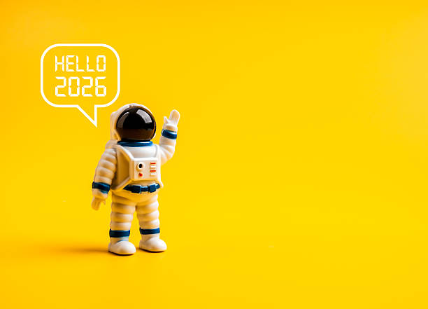 istock Cute astronaut figure waving with speech bubble Hello 2026 on yellow background with copy space. Futuristic and minimal new year greeting concept for 2026. Creative space-themed celebration idea. 2242108736