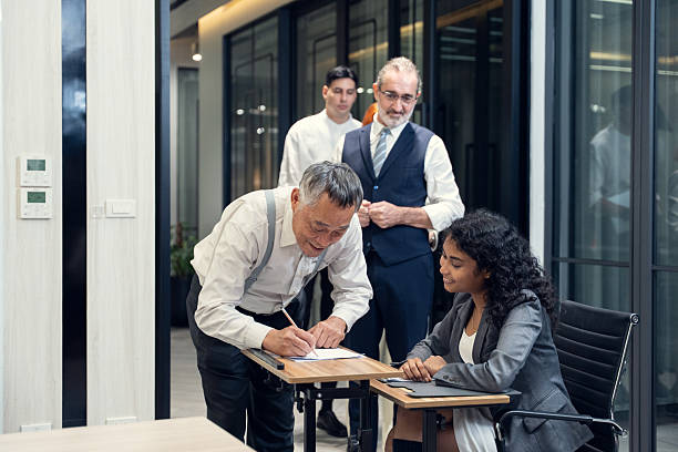 istock Business people checking in at conference registration table. International diverse corporate business partnership concept. 2242112247