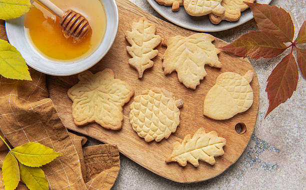 istock Autumn leaf cookies with honey on wooden board 2242114295