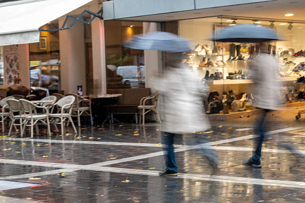 istock People walking with umbrellas through autumn city rain 2242115216