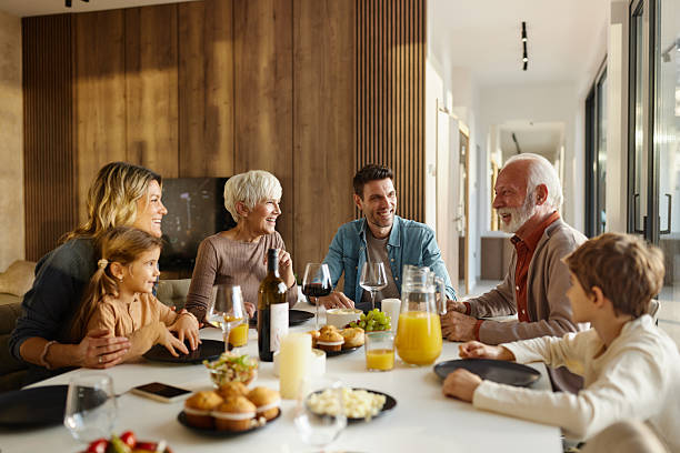 istock Happy extended family talking during lunch in dining room. 2242118798