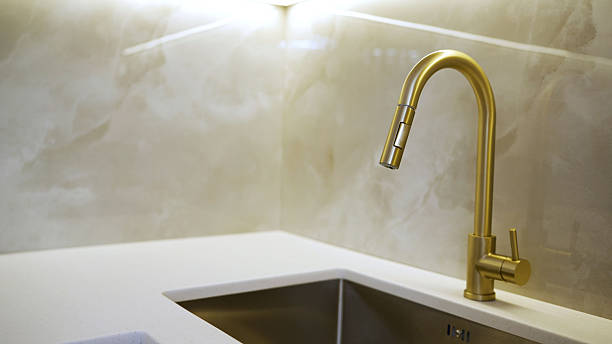 istock Golden kitchen faucet and white countertop 2242122426