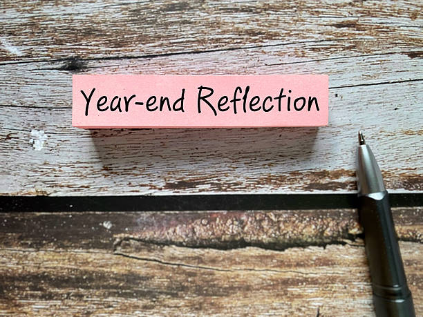 Year-end Reflection Concept with Pen on Wooden Table