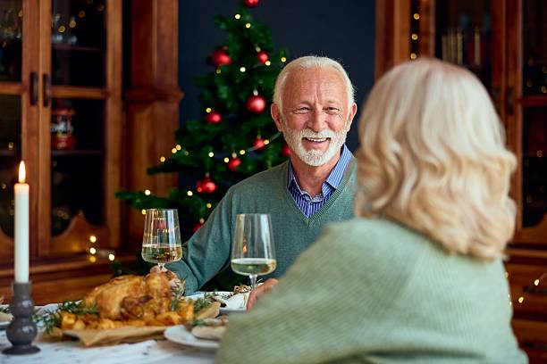 istock New Year Dinner With Elderly Couple At Festive Table By Christmas Tree 2242123179