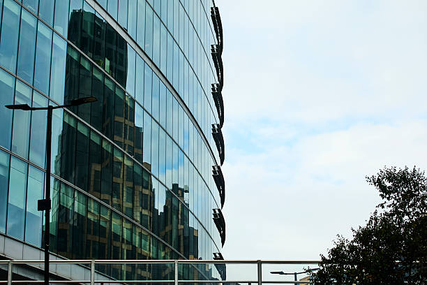 Close up image of a skyscraper facade made with glass windows, modern architecture and concrete blocks