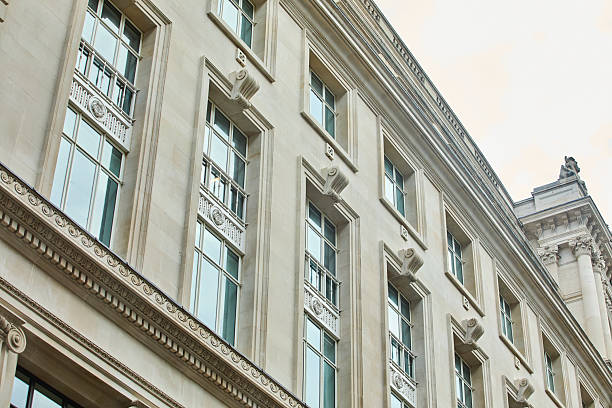 Close up image of a skyscraper facade made with glass windows, modern architecture and concrete blocks