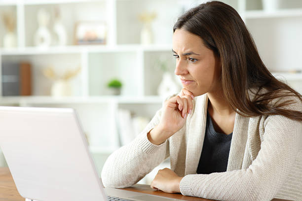 istock Suspicious woman checking laptop content in a house 2242125436
