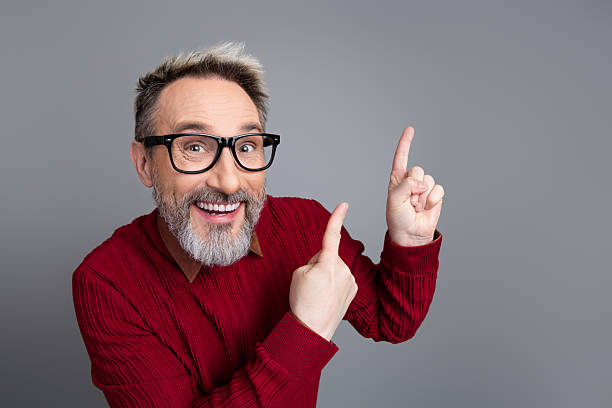 istock Handsome businessman with glasses gesturing upward to emphasize a concept against a minimalist gray backdrop 2242126968