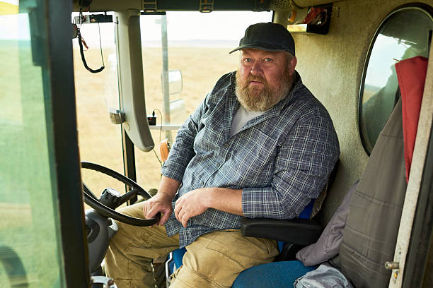 istock Portrait of Middle Aged Caucasian Man Sitting Inside Tractor Cabin Looking Forward 2242128762