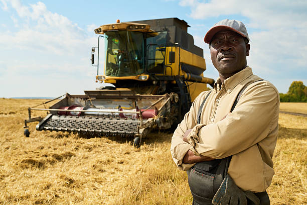 istock Middle Aged Black Man Standing Confidently in Front of Combine Harvester 2242129806