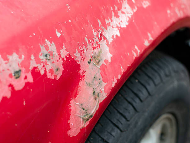 istock Deep scratch and peeling paint damage on red car body panel near wheel well showing primer and rust 2242130701