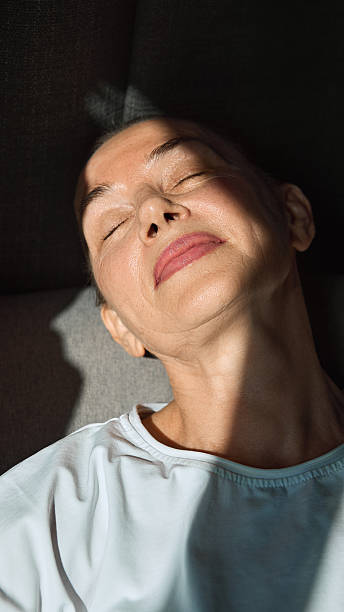istock Elderly woman with closed eyes relaxing in sunlight with peaceful expression 2242133265