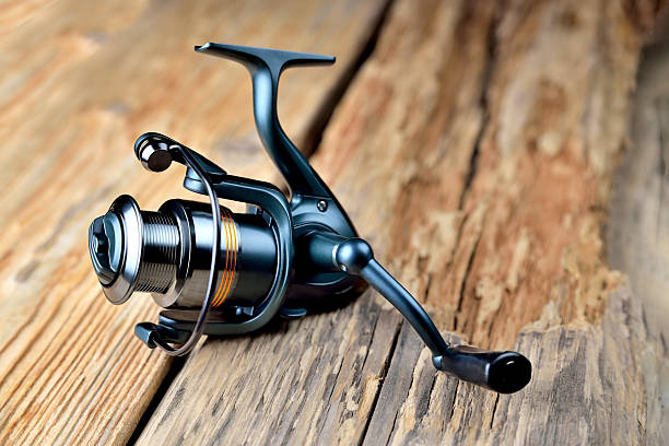 istock Fishing reel lies on old wooden background rustic background blank for creativity 2242140776