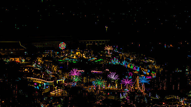 Ferris wheel or joint wheel ride running in night decorated with colourful lights at ground during the annual fair.
