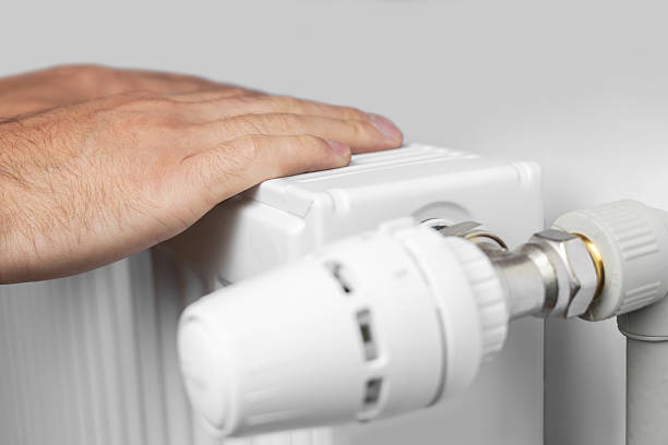 istock Man hands touching radiator, checking for heat in poorly heated home during cold season. 2242143120
