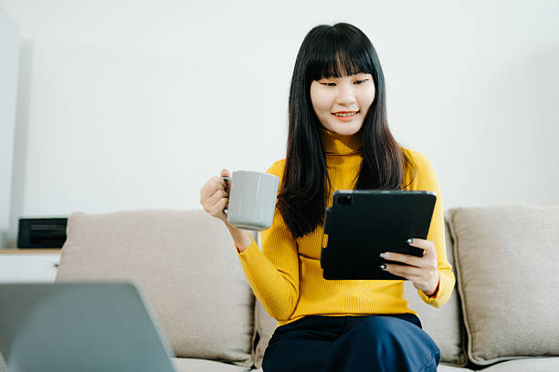istock Young woman relaxing on couch using smartphone and smiling while browsing onlineuse cellphone 2242144239