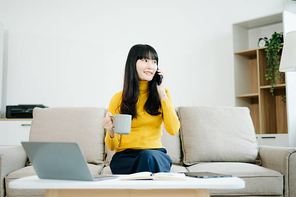 istock Young asian woman relax on comfortable couch at home texting messaging on smartphone and tablet 2242144242