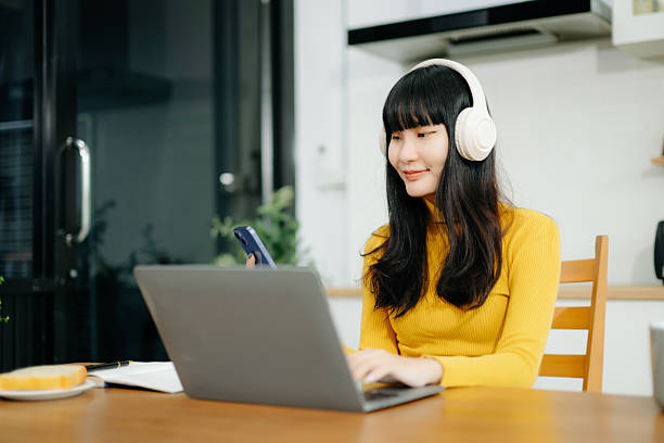istock Woman using laptop checking email news online sitting on sofa,  working on computer, writing blog 2242144243