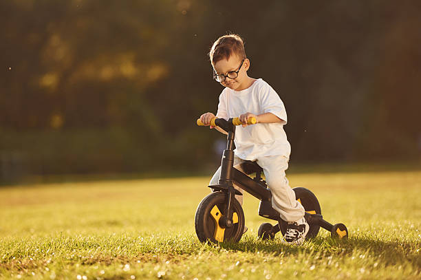 istock On the small bicycle. Boy is having fun on the field under sunlight at daytime 2242145196
