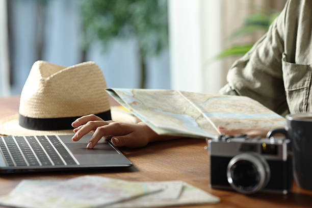 istock Tourist planning vacation checking maps and laptop 2242145403