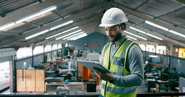 istock Engineer, online and man with tablet, warehouse and performance review on website and manufacturing. Reading, research and person with tech for quality control, production and safety with helmet 2242145644