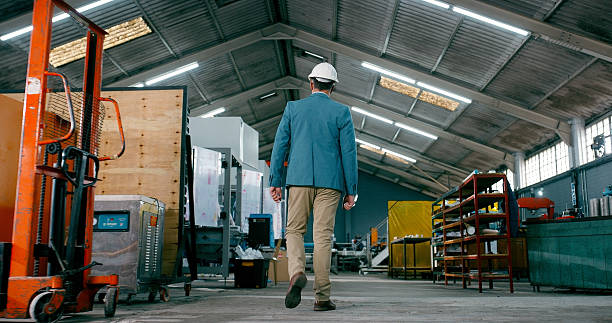 istock Back, businessman or walk in warehouse for manufacturing solution, quality control or safety compliance. Supply chain, manager and journey in factory for development, problem solving and supervision. 2242145699