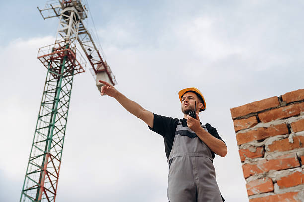 istock Giving orders by using walkie talkie. A builder is working at the construction site at daytime 2242147731
