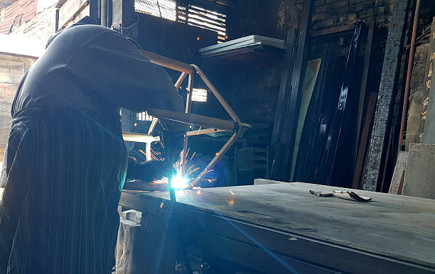 Poor old skilled Pakistani Welder welding pipes and metal rods in his street workshop