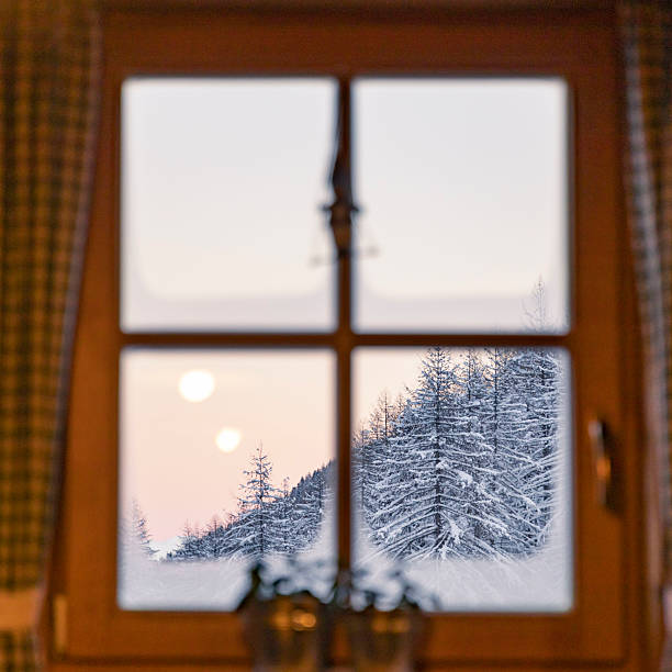 Window facing snowy mountain with out of focus window in the foreground